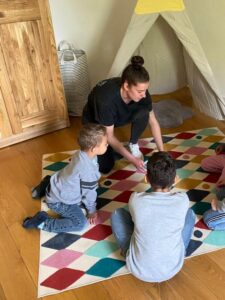 Gruppenleiterin Anna-Lena Morsch spielt mit den Kindern im Kinderzimmer vor dem Tipi-Zelt
